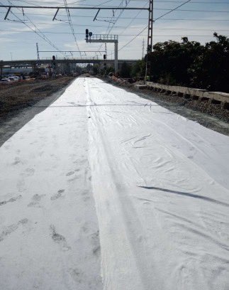 10.11.2024. Red convencional: Tras la estabilización con cemento de la plataforma se extiende un geotextil/manta artificial que tiene un doble objetivo. Por un lado, dar mayor resistencia mecánica y de punzonamiento a  la plataforma sobre la que se extiende y, por otro, evitar que se contamine el balastro superior de finos y arcilla ya que dicho geotéxtil es permeable, pero no permite el paso de finos, lodos y arcillas.