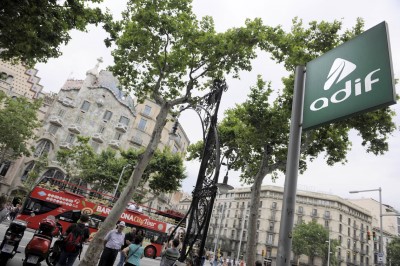 Señalización de Adif de entrada a la estación con la Casa Batlló al fondo